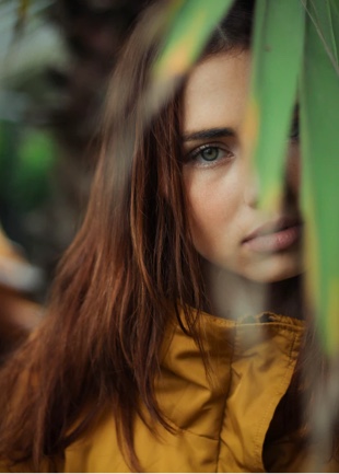 Women looking towards you behind leaves