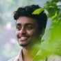 man smiling with leaves in the background